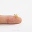 a tiny gold giraffe ring sitting on top of a finger