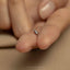 a person holding a tiny ring in their hand