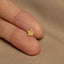 a person&#39;s hand holding a tiny gold star of david ring