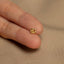 a person&#39;s hand holding a tiny gold ring