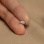 a person&#39;s hand holding a tiny silver bird ring