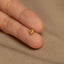 a person&#39;s hand holding a tiny yellow diamond