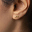 a close up of a person&#39;s ear with a gold earring