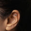 a close up of a person wearing a pair of ear piercings