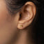 a close up of a woman&#39;s ear with a gold stud