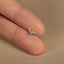 a tiny silver bird on top of a finger