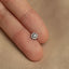 a person&#39;s finger with a small diamond ring on it