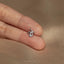 a person&#39;s hand holding a tiny diamond ring