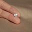 a person&#39;s hand holding a tiny heart shaped ring