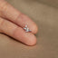 a person&#39;s hand holding a tiny ring with a bird on it