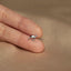 a person&#39;s hand holding a tiny silver bird ring