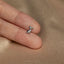 a person&#39;s hand holding a tiny silver bird ring