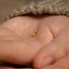 a tiny gold ring is held in someone&#39;s hand