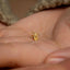 a person&#39;s hand holding a tiny gold ring