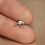 a small silver kangaroo brooch sitting on top of a person&#39;s finger