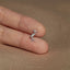 a person&#39;s hand holding a tiny bird ring