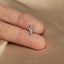 a person&#39;s hand with a tiny nose ring on it