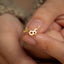 a close up of a person holding a gold ring