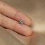 a person&#39;s hand holding a tiny silver flower ring